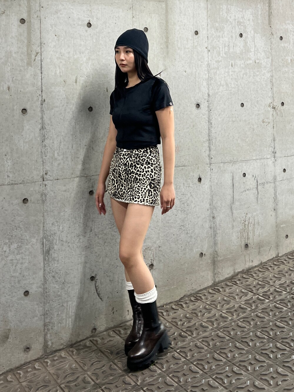 ホワイト系のスカート、ブラック系のTシャツ/カットソー、ブラック系のブーツを着用したレディースの夏コーディネートの2枚目の写真