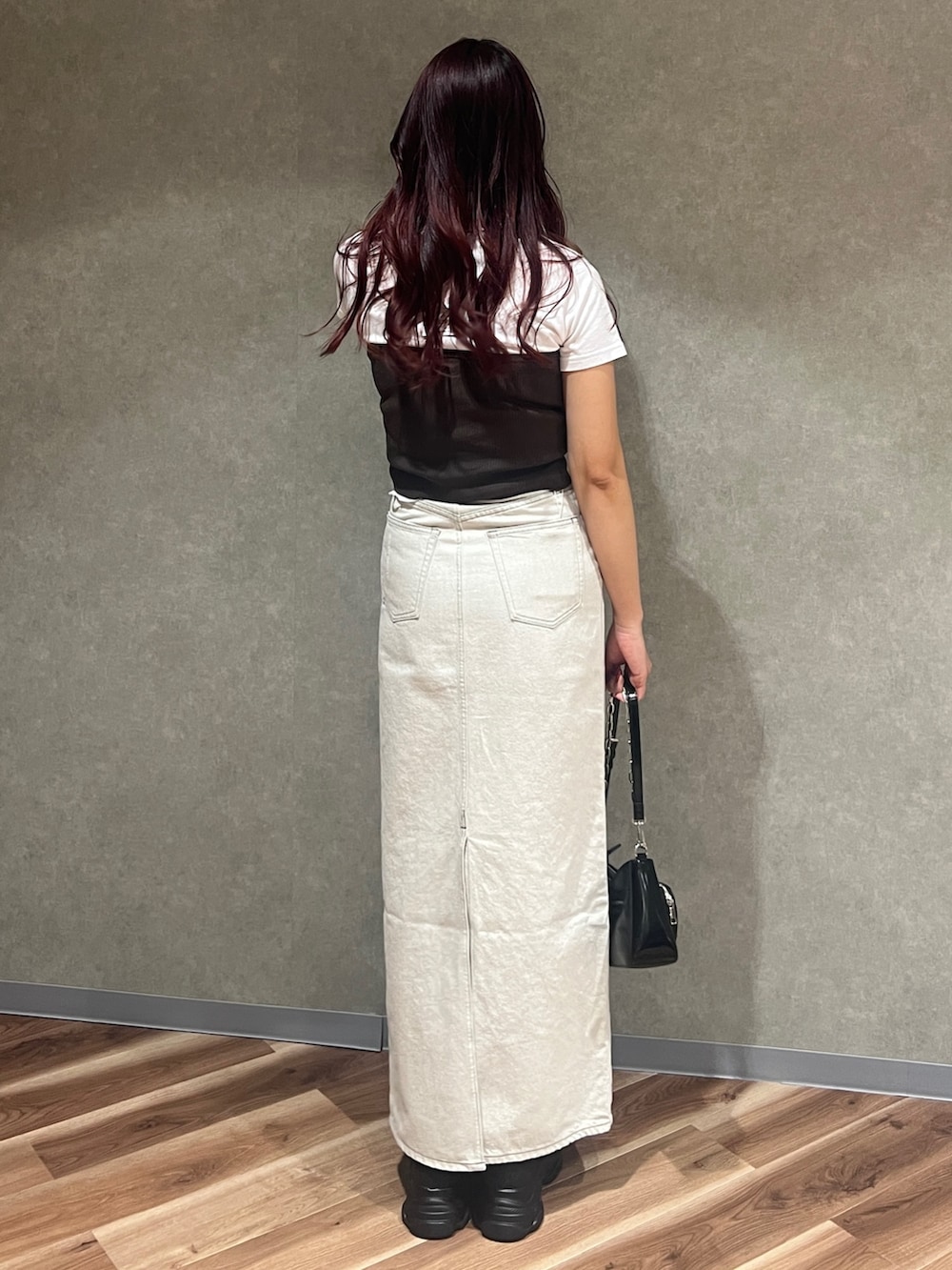 ブラウン系のチューブトップ、ホワイト系のTシャツ/カットソー、ブラック系のショルダーバッグを着用したレディースの春コーディネートの4枚目の写真