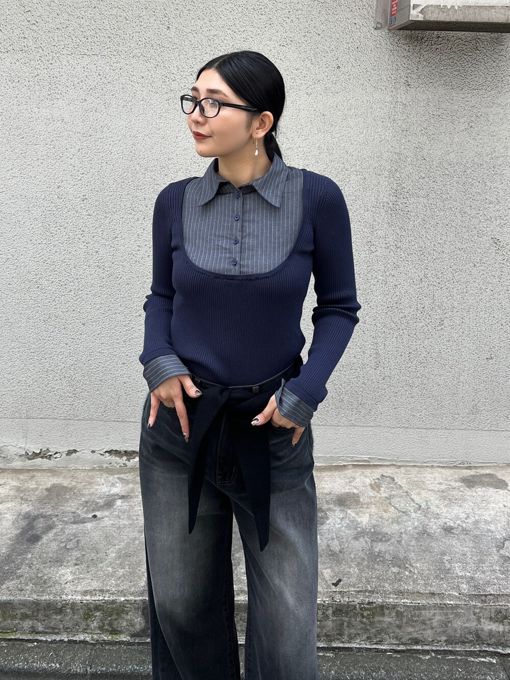 ブルー系のニット/セーター、ブラック系のブーツ、ブラック系のデニムパンツを着用したレディースの夏コーディネートの4枚目の写真