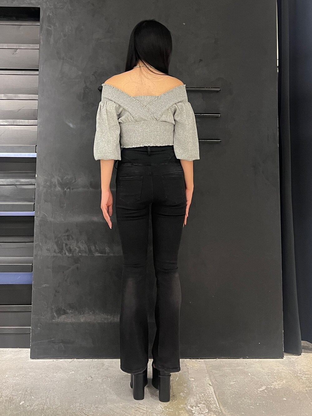 ブラック系のデニムパンツ、ブラック系のサンダル、グレー系のTシャツ/カットソーを着用したレディースの春コーディネートの2枚目の写真