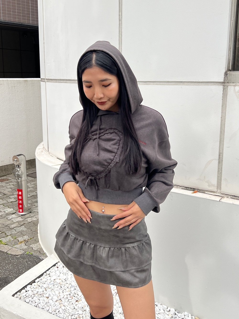 ブラック系のパーカー、グレー系のスカート、ブラック系のブーツを着用したレディースの秋コーディネートの3枚目の写真