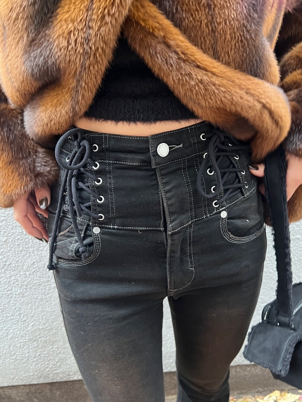 ブラウン系のその他アウター、ブラック系のニット/セーター、ブラック系のデニムパンツを着用したレディースの冬コーディネートの6枚目の写真