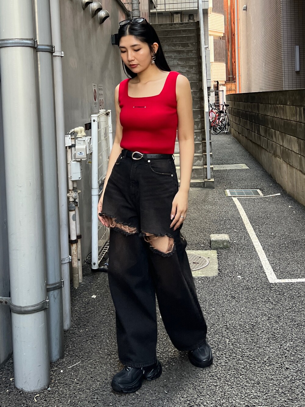 レッド系のTシャツ/カットソー、ブラック系のデニムパンツ、ブラック系のスニーカーを着用したレディースの夏コーディネートの2枚目の写真