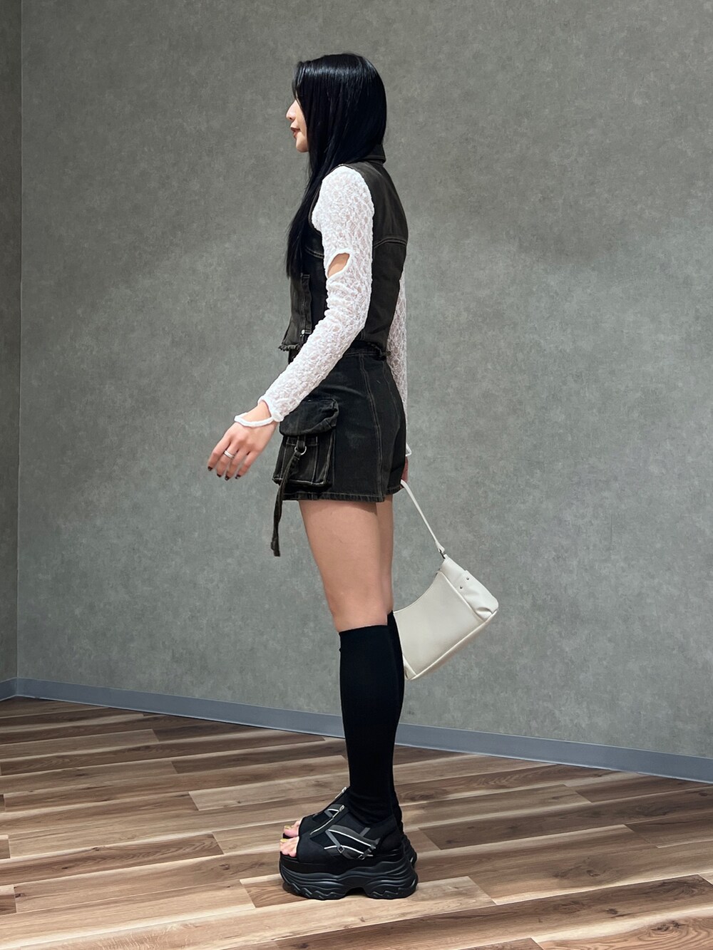 ブラック系のベスト、ブラック系のその他パンツ、ホワイト系のハンドバッグを着用したレディースの春コーディネートの2枚目の写真