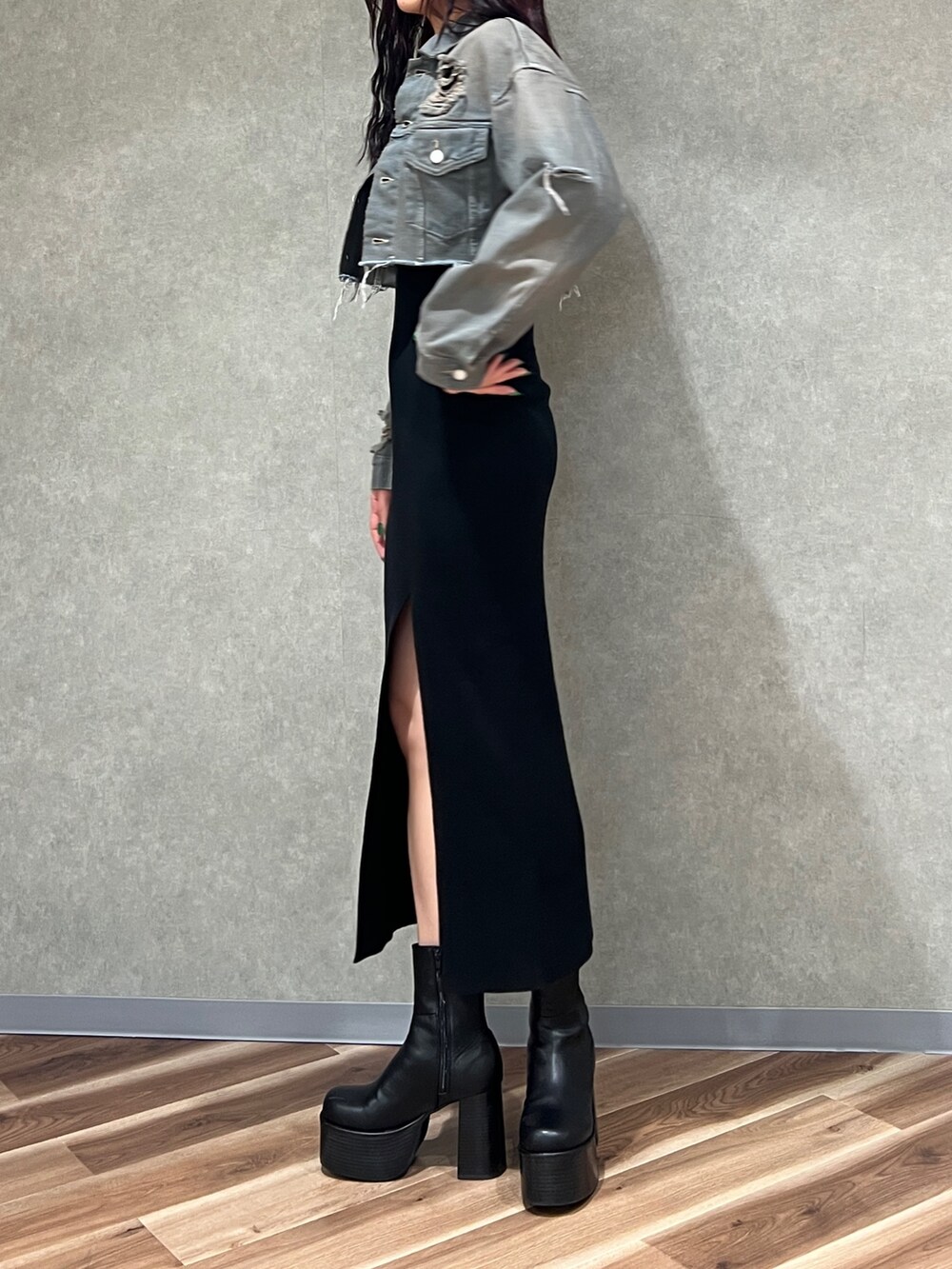 グレー系のデニムジャケット、ブラック系のワンピース、ブラック系のブーツを着用したレディースの冬コーディネートの2枚目の写真