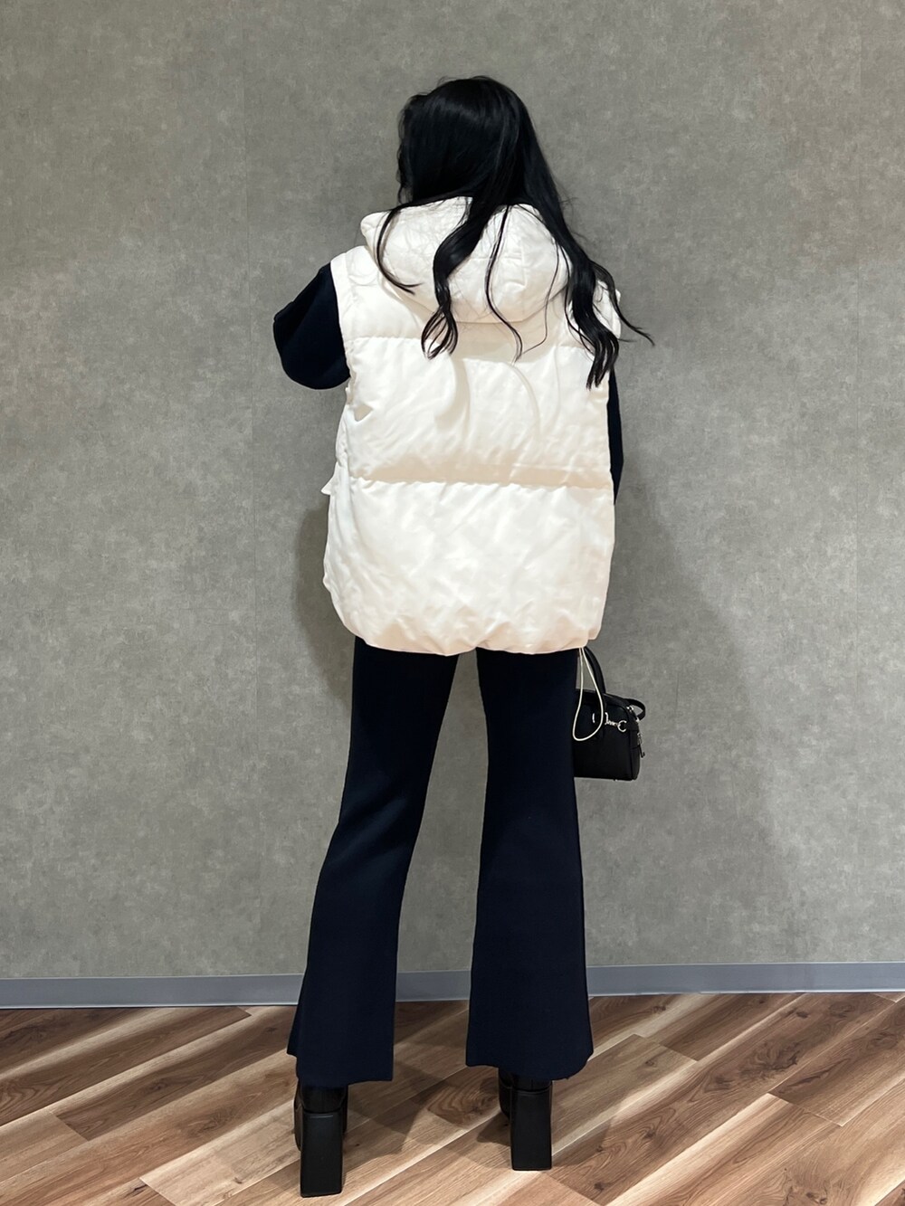 ホワイト系のブルゾン、ブラック系のニット/セーター、ブルー系のその他パンツを着用したレディースの秋コーディネートの4枚目の写真