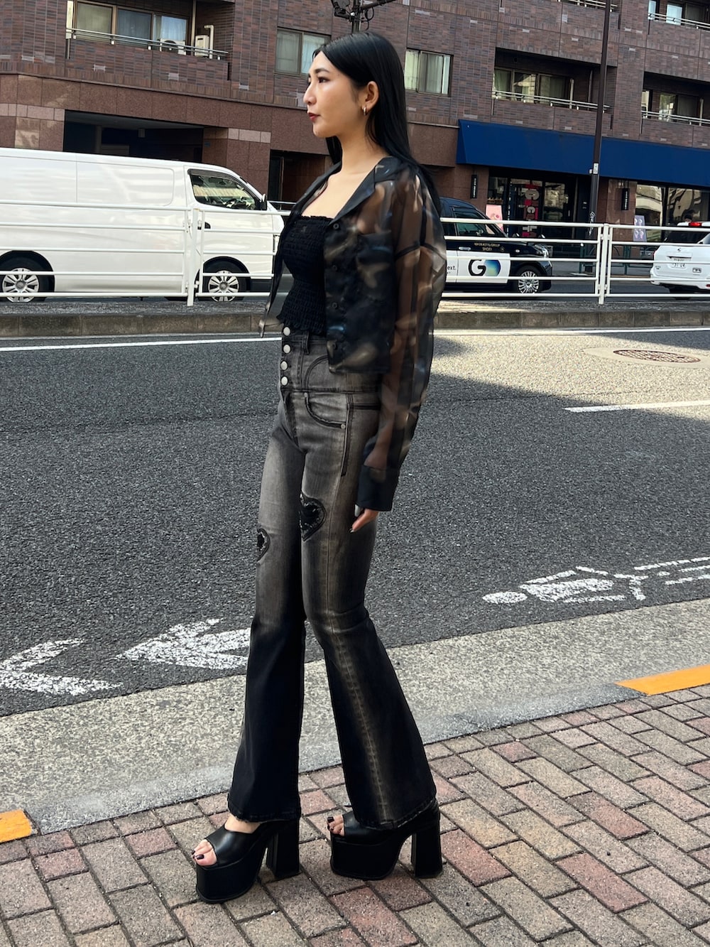 ブラック系のキャミソール、ブラック系のデニムパンツ、ブラック系のサンダルを着用したレディースの春コーディネートの2枚目の写真