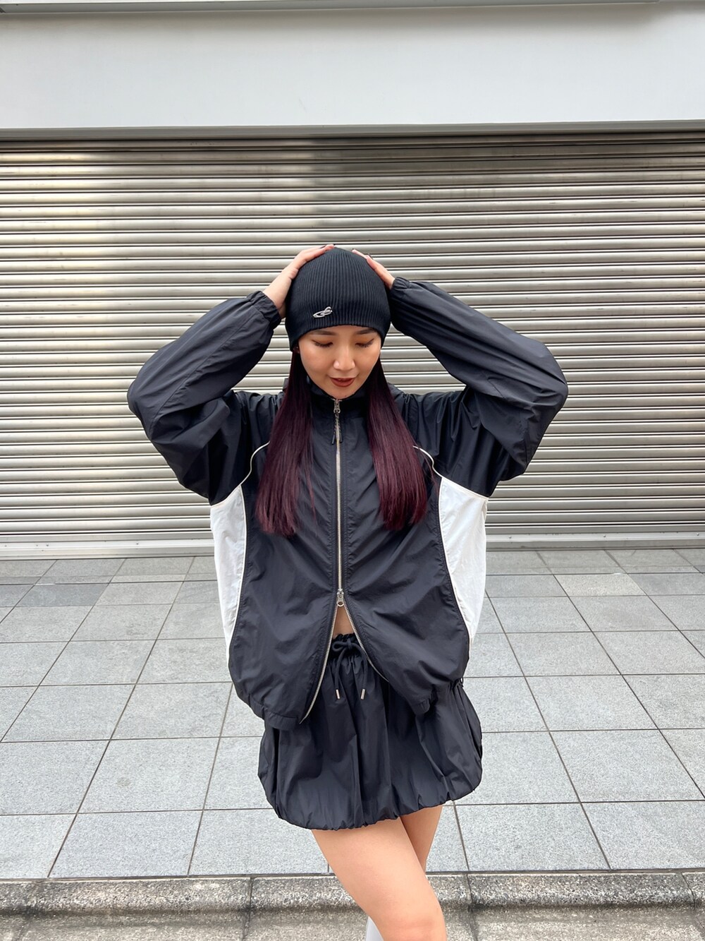 ブラック系のブルゾン、ブラック系のスカート、ホワイト系のスニーカーを着用したレディースの冬コーディネートの5枚目の写真