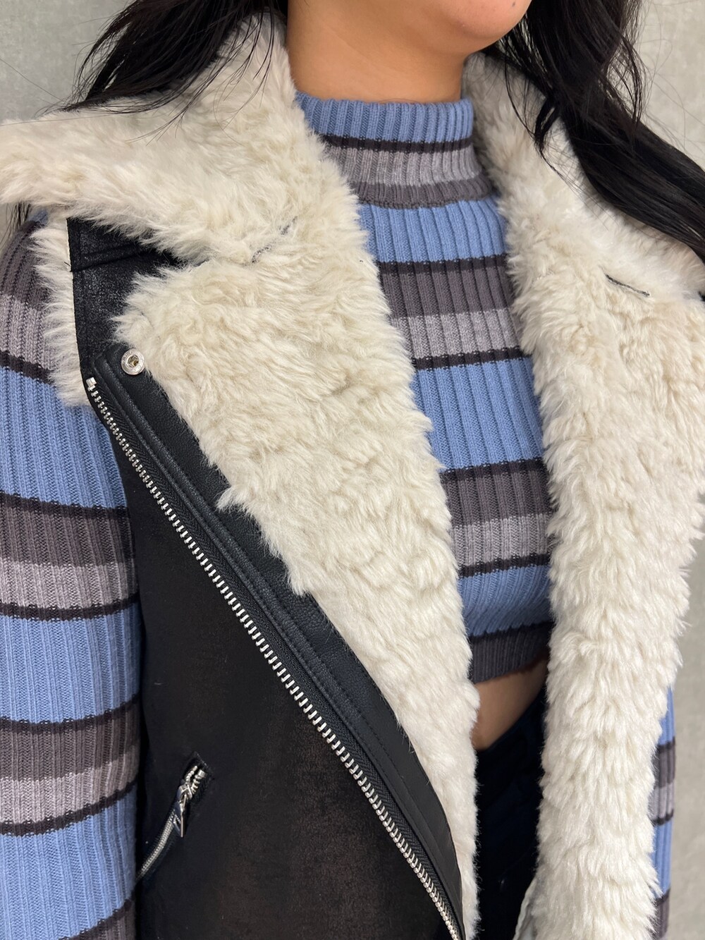 ブラック系のデニムパンツ、ブラック系のムートンコート、その他のニット/セーターを着用したレディースの秋コーディネートの4枚目の写真