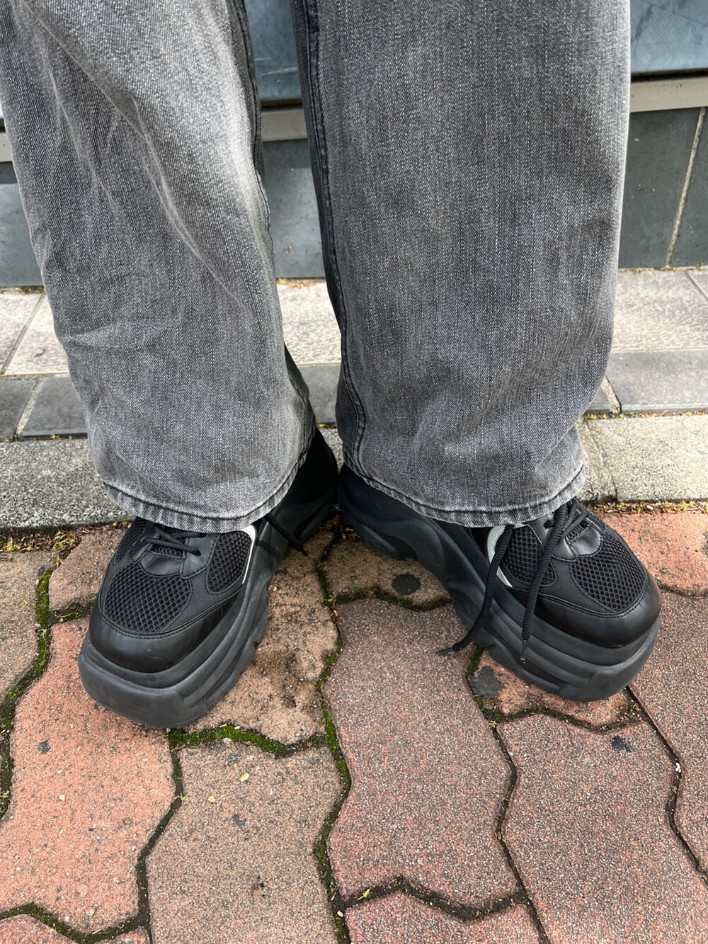 ブラック系のTシャツ/カットソー、ブラック系のスニーカー、ブラック系のハンドバッグを着用したレディースの春コーディネートの5枚目の写真