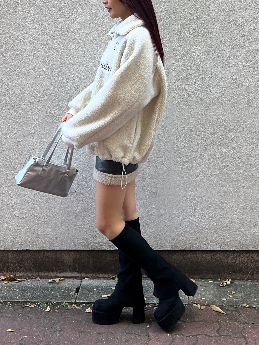 ホワイト系のTシャツ/カットソー、グレー系のスカート、ブラック系のブーツを着用したレディースの秋コーディネートの2枚目の写真