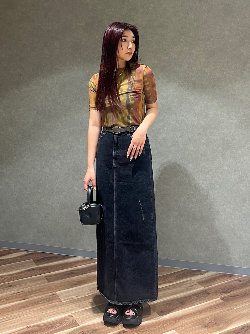 ブラック系のキャミソール、オレンジ系のTシャツ/カットソー、ブラック系のスカートを着用したレディースの夏コーディネートの2枚目の写真