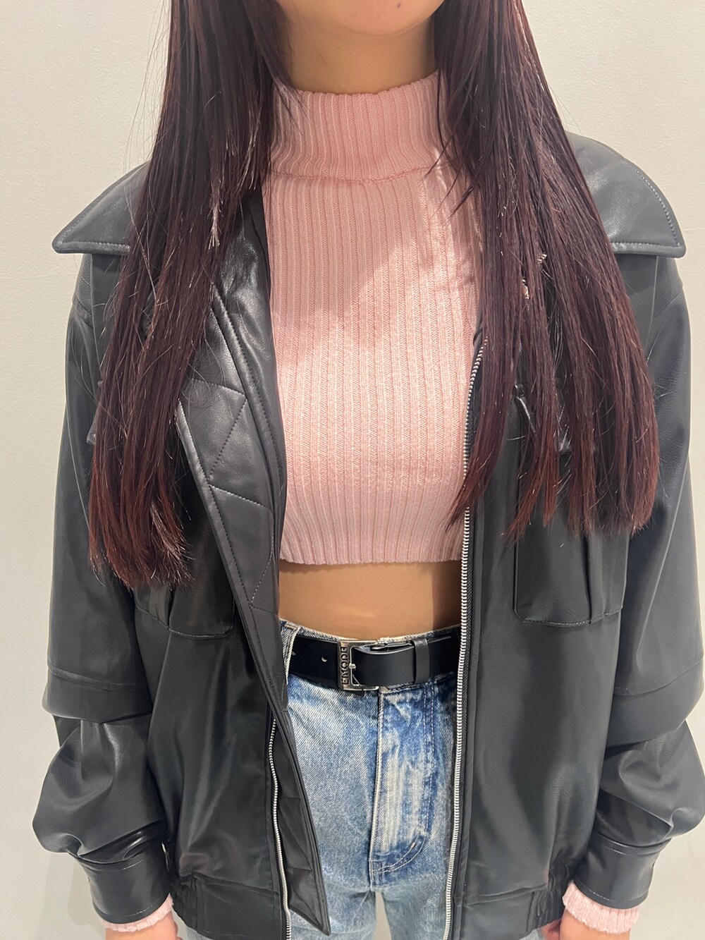 ピンク系のニット/セーター、ブラック系のブルゾン、ブルー系のデニムパンツを着用したレディースの冬コーディネートの4枚目の写真