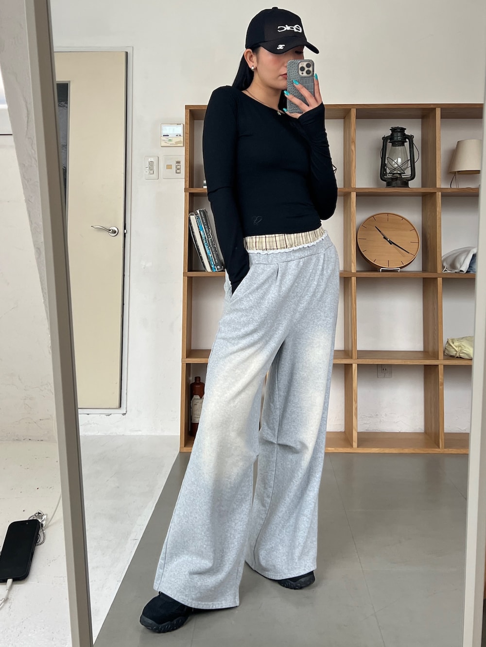 ブラック系のスウェットパンツ、ブラック系のスニーカー、ブラック系のキャップを着用したレディースの春コーディネートの2枚目の写真