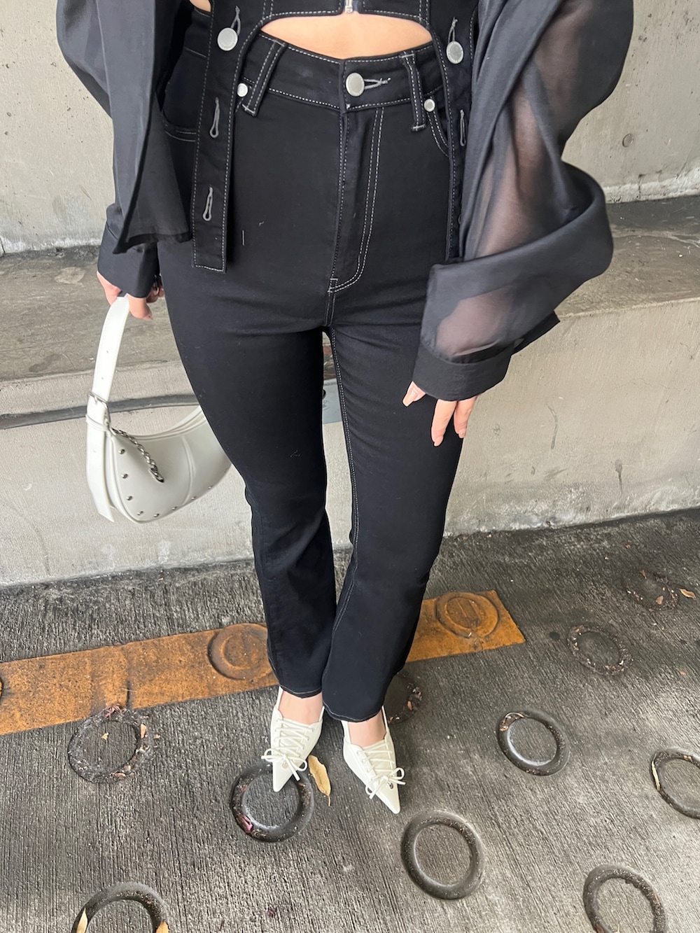 ブラック系のサロペット/オーバーオール、ブラック系のシャツ/ブラウス、ホワイト系のハンドバッグを着用したレディースの春コーディネートの5枚目の写真