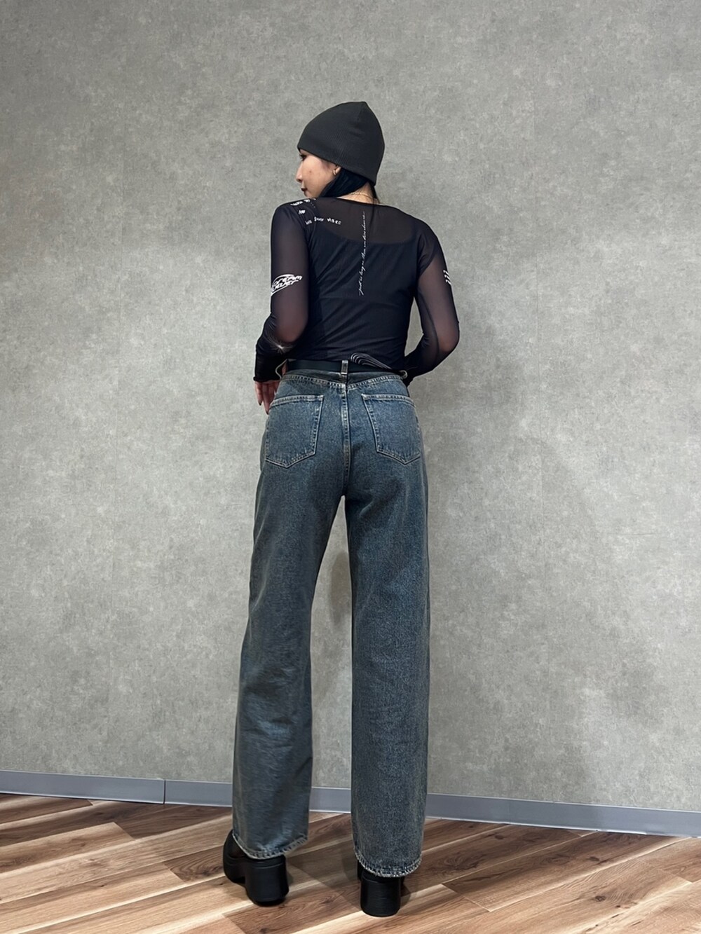 ブラック系のTシャツ/カットソー、ブルー系のデニムパンツ、ブラック系のブーツを着用したレディースの秋コーディネートの4枚目の写真