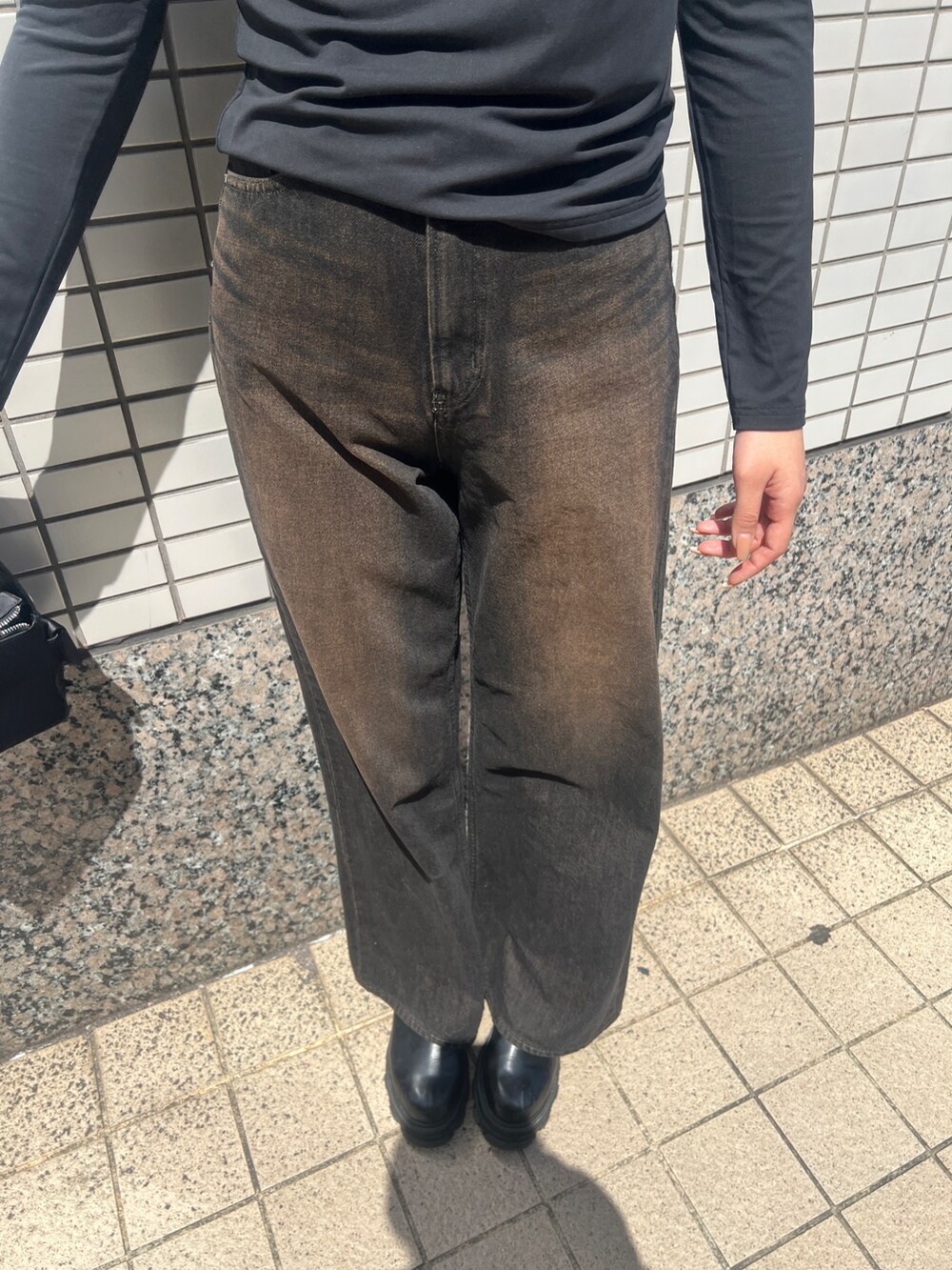 ブラック系のデニムパンツ、ブラック系のブーツ、ブラック系のTシャツ/カットソーを着用したレディースの春コーディネートの5枚目の写真