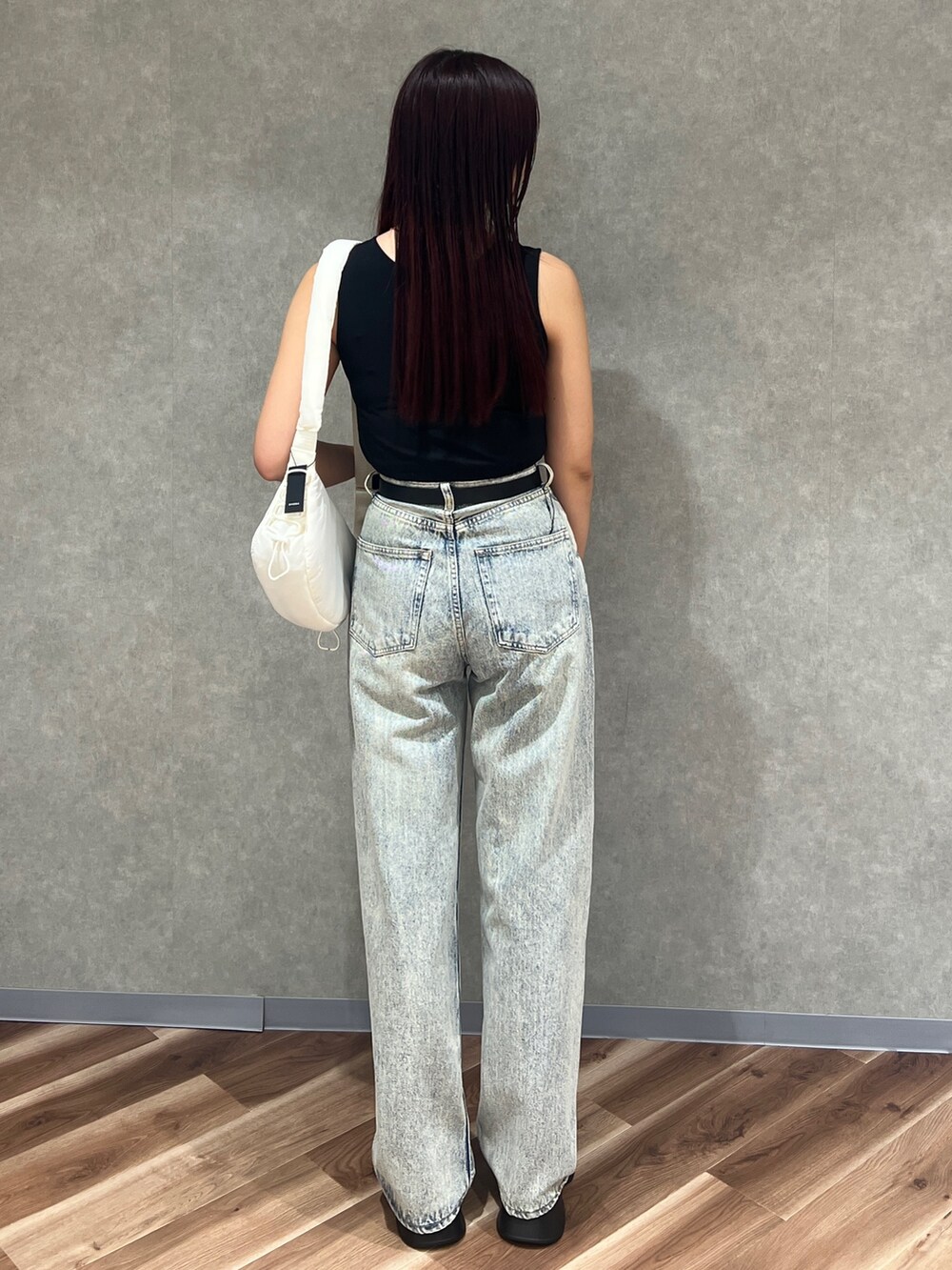 ブラック系のタンクトップ、ブルー系のデニムパンツ、ホワイト系のサンダルを着用したレディースの春コーディネートの3枚目の写真