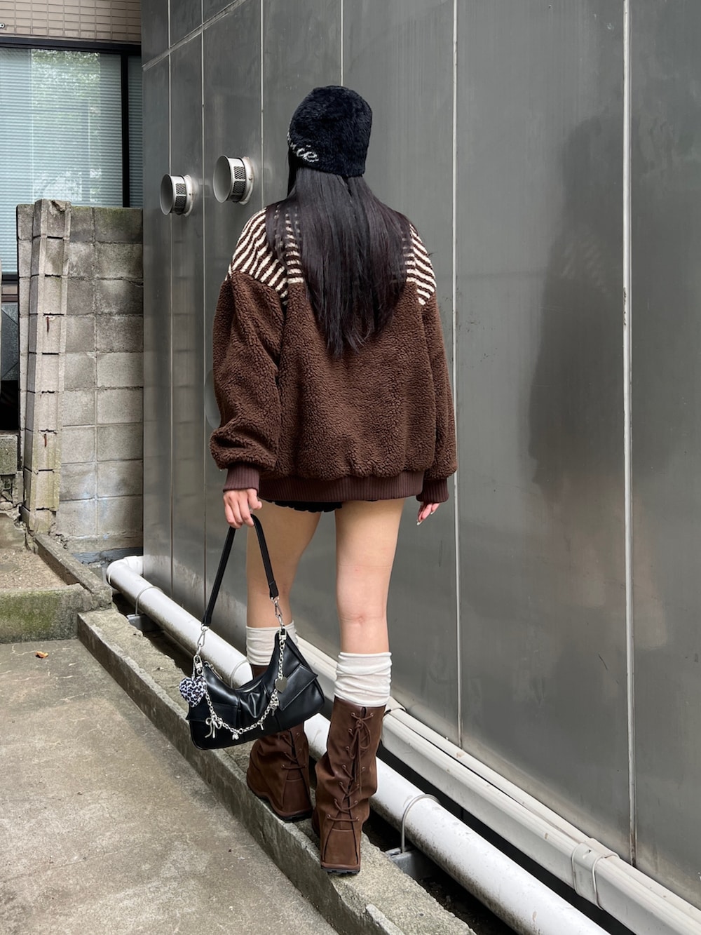 ブラウン系のブーツ、ブラック系のその他パンツ、ブラウン系のブルゾンを着用したレディースの秋コーディネートの3枚目の写真