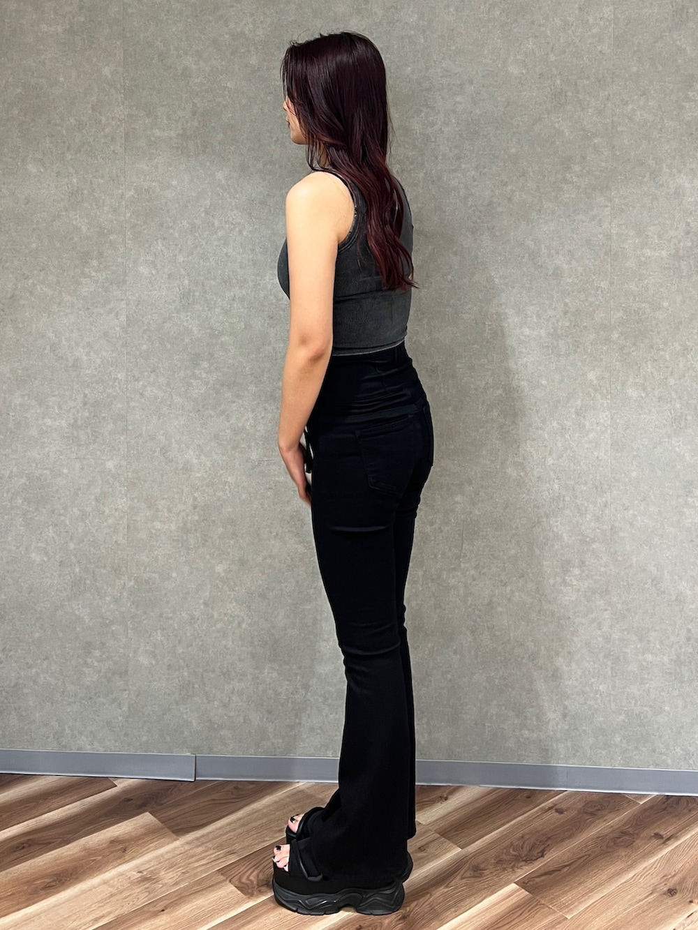 ブラック系のタンクトップ、ブラック系のデニムパンツ、ブラック系のサンダルを着用したレディースの夏コーディネートの2枚目の写真