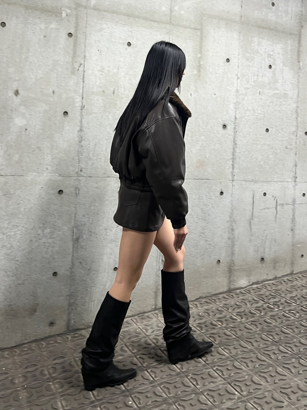 ブラック系のブルゾン、ブラウン系のスカート、ブラック系のブーツを着用したレディースの秋コーディネートの3枚目の写真