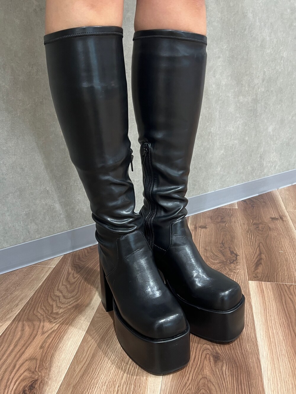 ブラック系のムートンコート、ブラック系のブーツ、グレー系のワンピースを着用したレディースの秋コーディネートの6枚目の写真