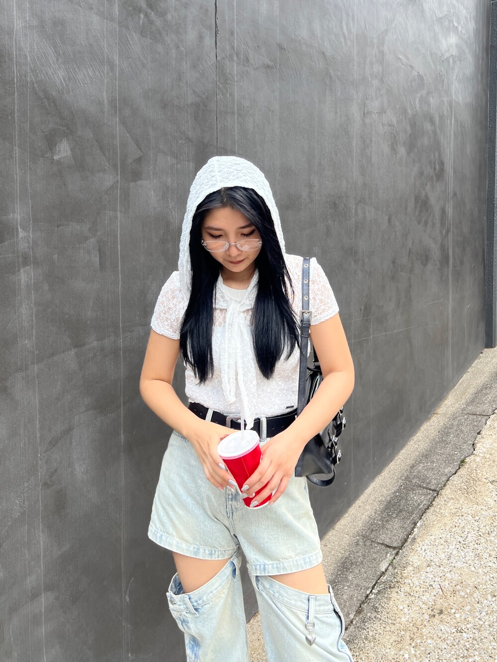 ホワイト系のTシャツ/カットソー、ブルー系のデニムパンツ、ブラック系のハンドバッグを着用したレディースの夏コーディネートの4枚目の写真