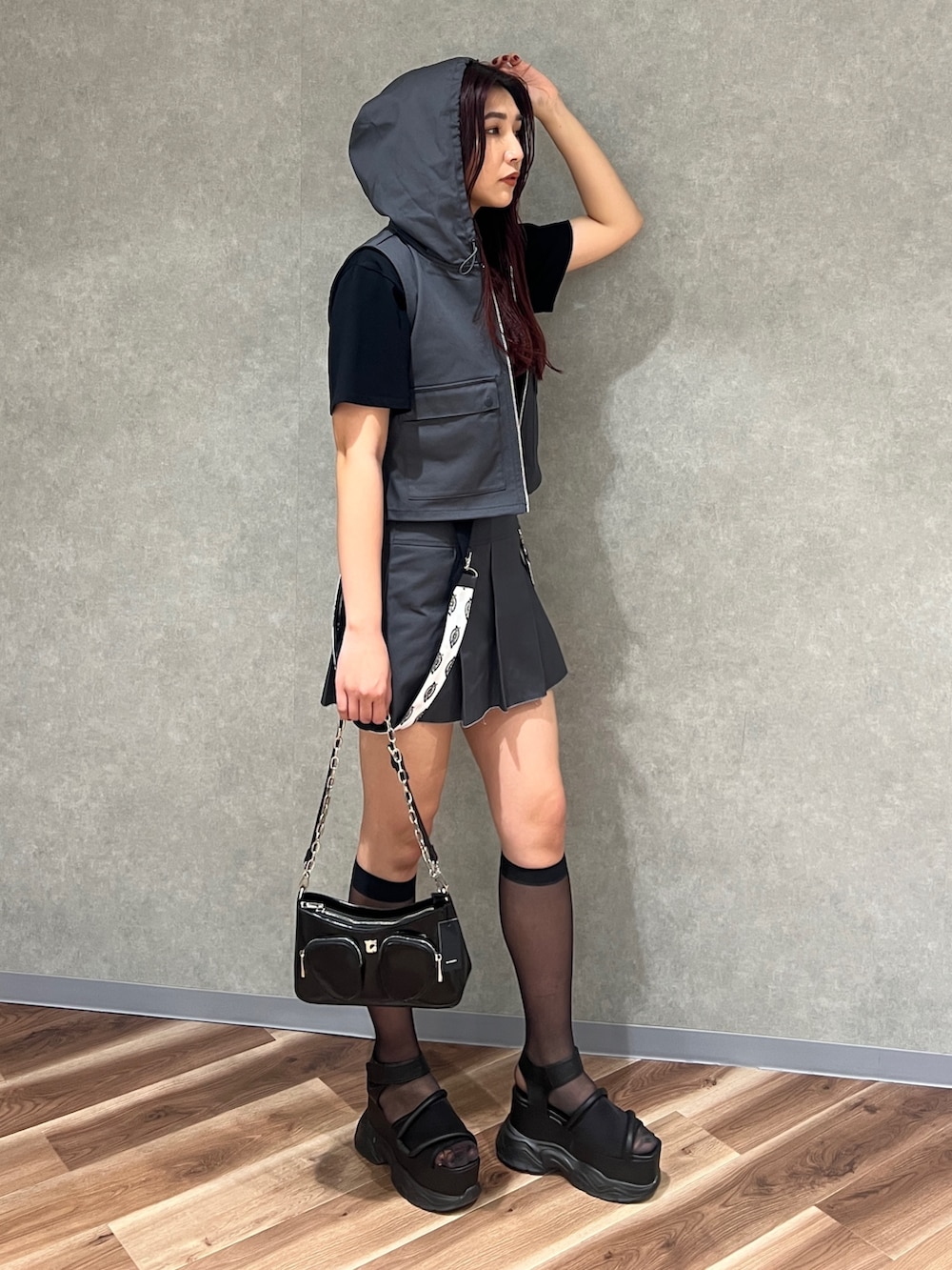 グレー系のベスト、ブラック系のTシャツ/カットソー、グレー系のスカートを着用したレディースの春コーディネートの5枚目の写真