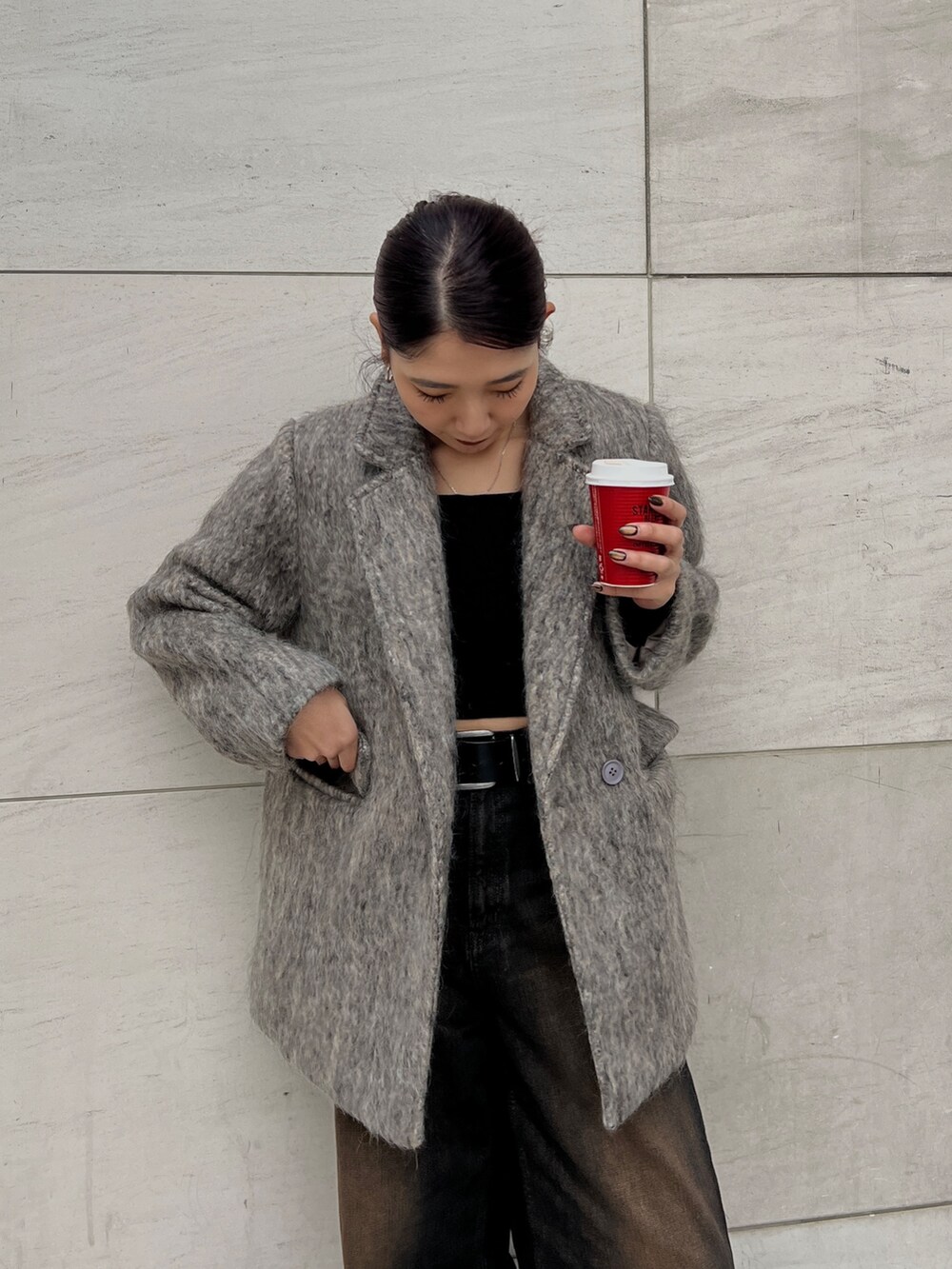 ブラック系のデニムパンツ、ブラック系のブーツ、ベージュ系のテーラードジャケットを着用したレディースの冬コーディネートの4枚目の写真