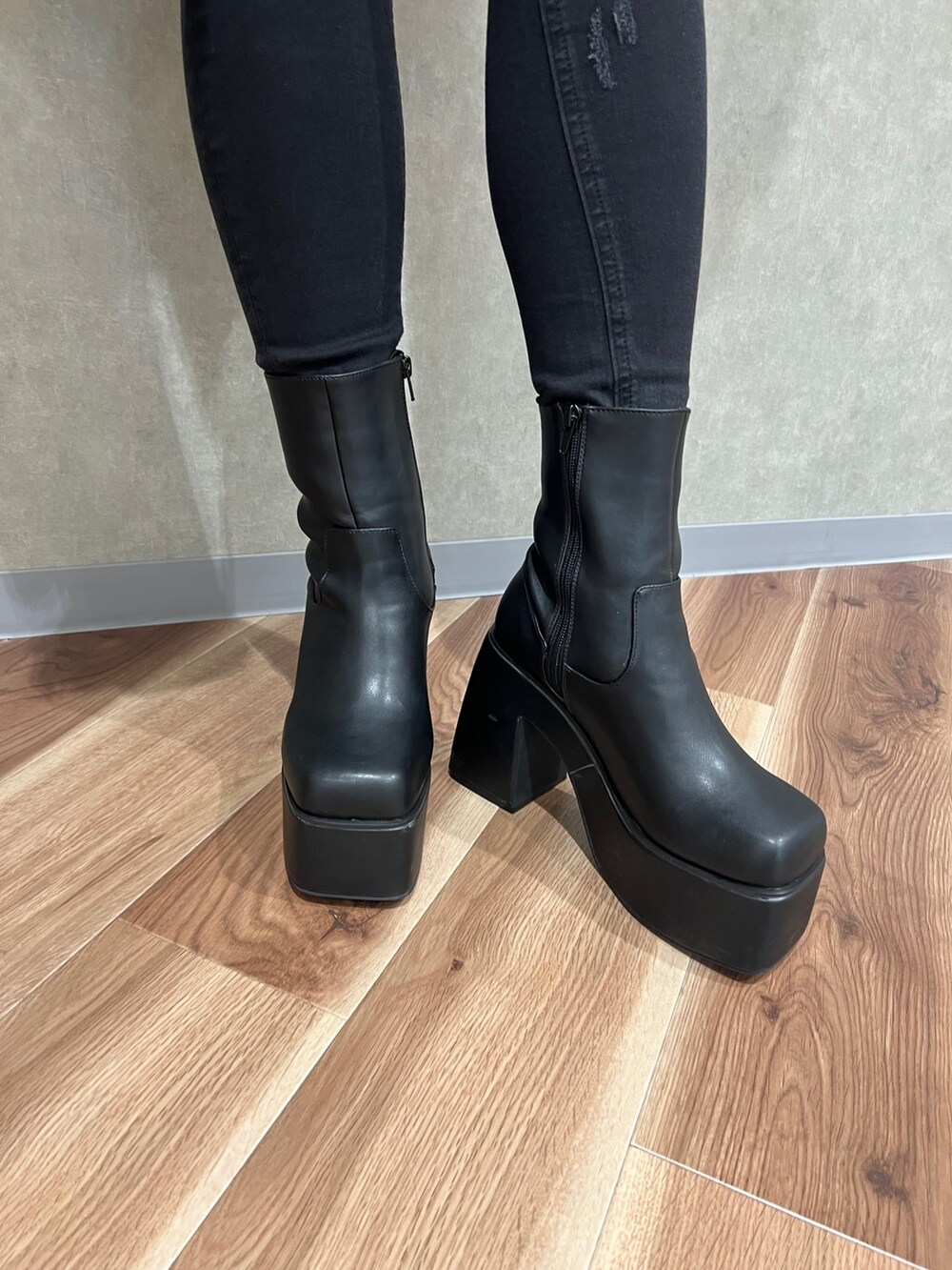 グレー系のニット/セーター、ブラック系のデニムパンツ、ブラック系のブーツを着用したレディースの秋コーディネートの7枚目の写真