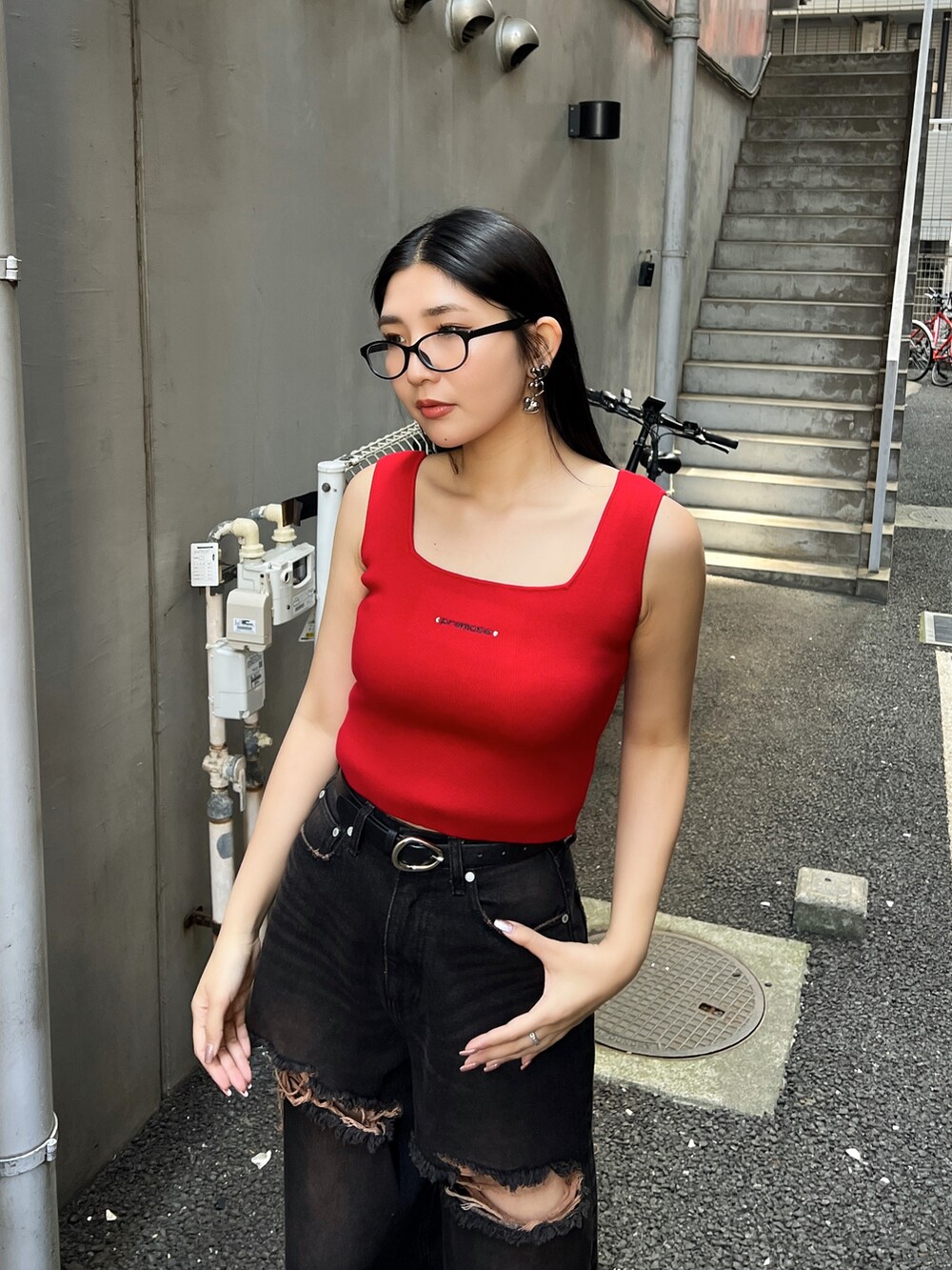 レッド系のTシャツ/カットソー、ブラック系のデニムパンツ、ブラック系のスニーカーを着用したレディースの夏コーディネートの3枚目の写真