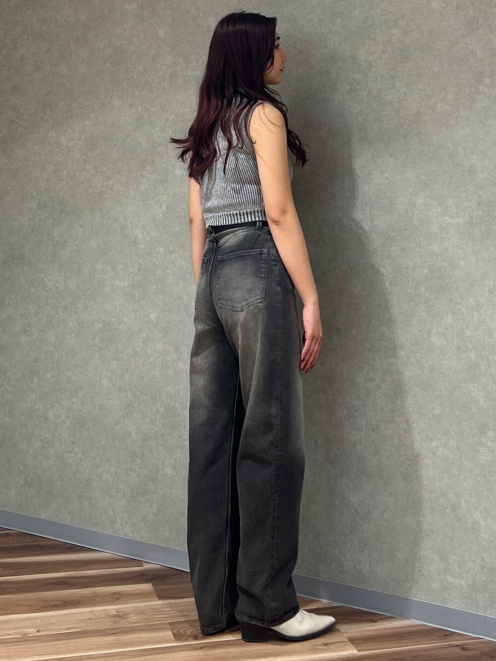 グレー系のニット/セーター、グレー系のデニムパンツ、ブラック系のサンダルを着用したレディースの春コーディネートの3枚目の写真