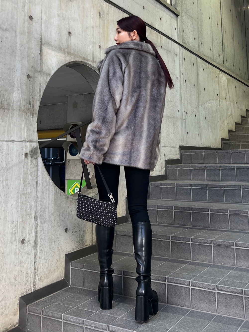 グレー系のその他アウター、ブラック系のニット/セーター、ブラック系のデニムパンツを着用したレディースの冬コーディネートの4枚目の写真