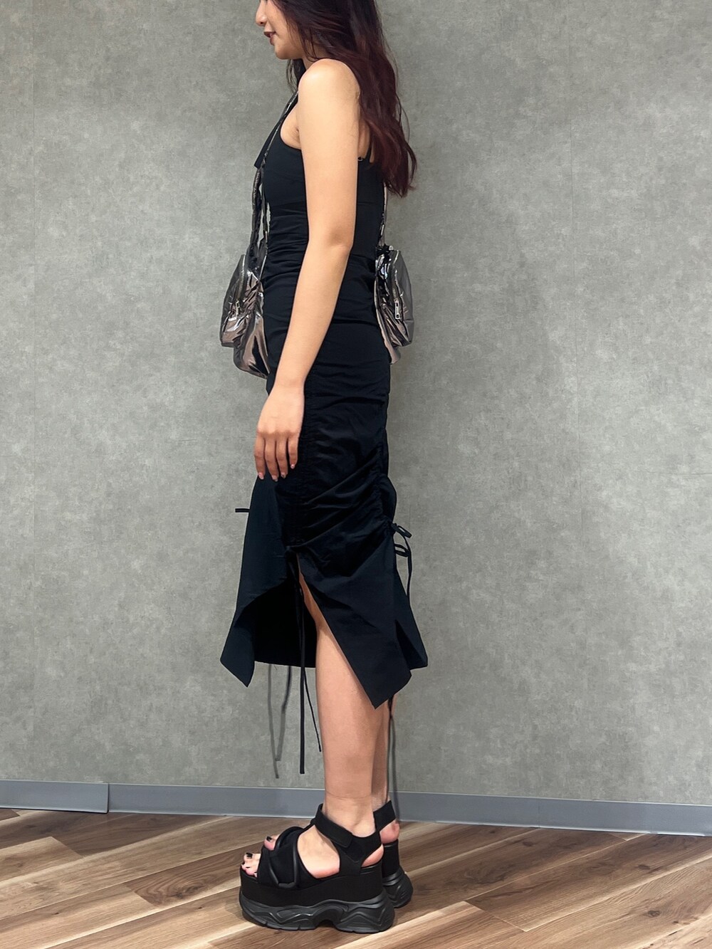 ブラック系のワンピース、シルバー系のハンドバッグ、ブラック系のサンダルを着用したレディースの夏コーディネートの3枚目の写真