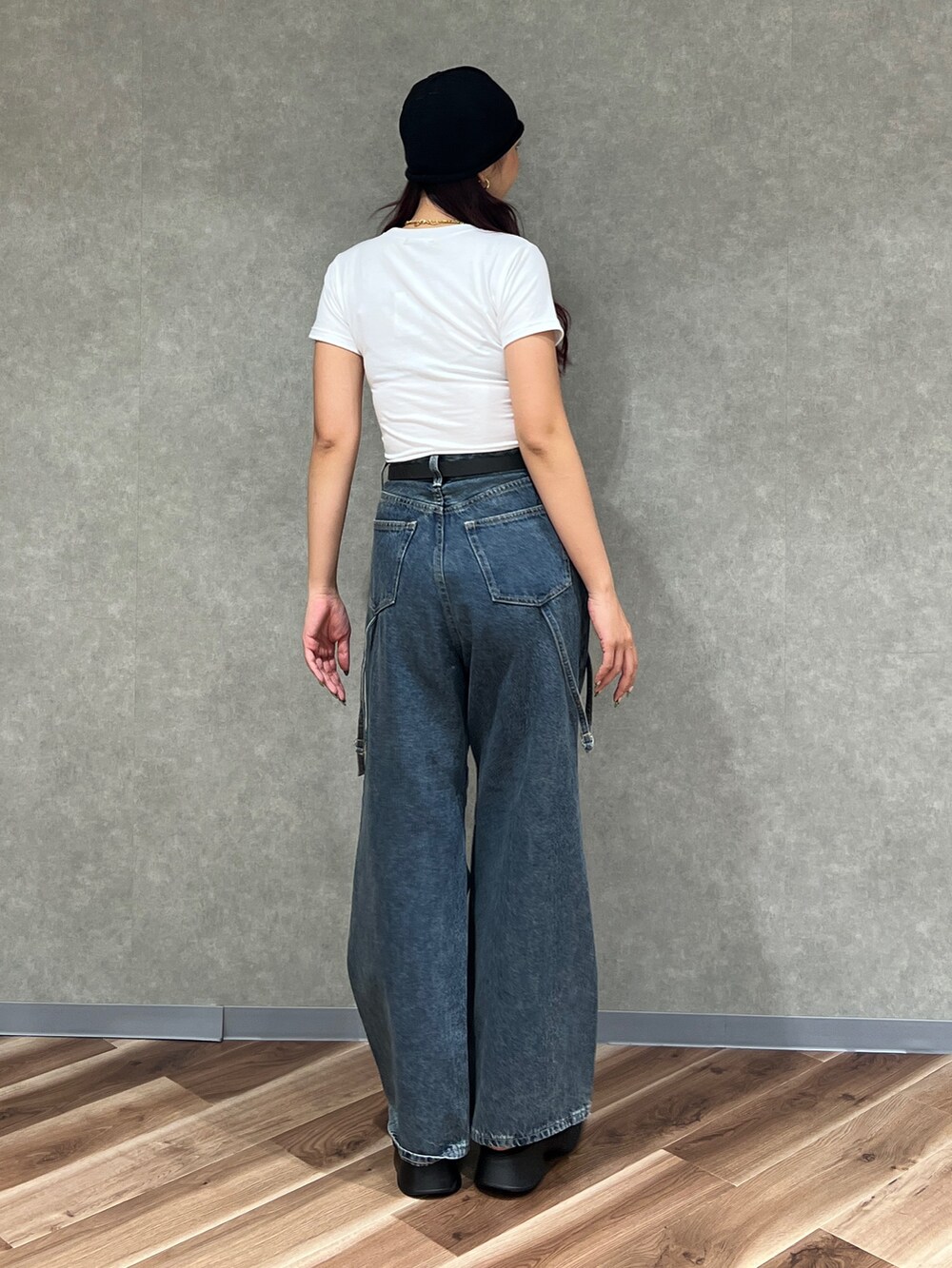 ブルー系のデニムパンツ、ブラック系のサンダル、ホワイト系のTシャツ/カットソーを着用したレディースの夏コーディネートの3枚目の写真