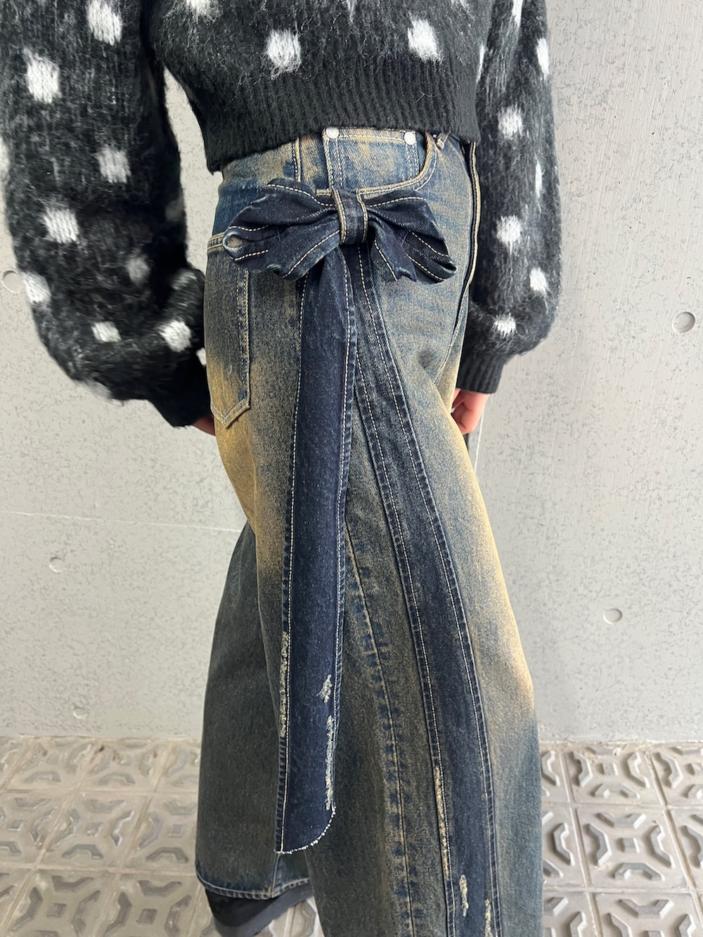 ブラック系のニット/セーター、ブルー系のデニムパンツ、ブラック系のスリッポンを着用したレディースの夏コーディネートの6枚目の写真
