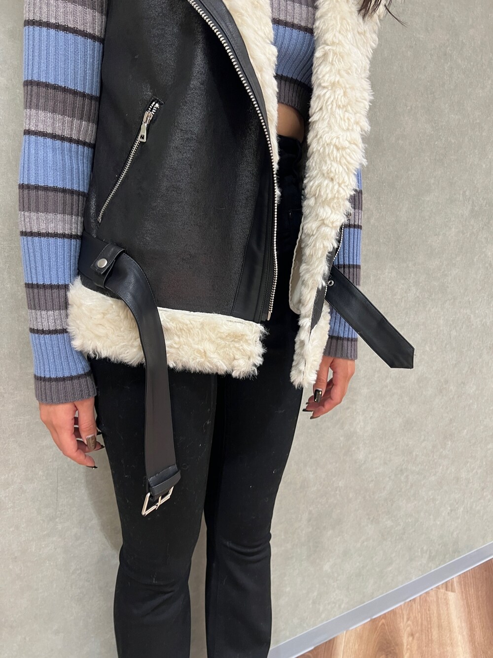 ブラック系のデニムパンツ、ブラック系のムートンコート、その他のニット/セーターを着用したレディースの秋コーディネートの5枚目の写真