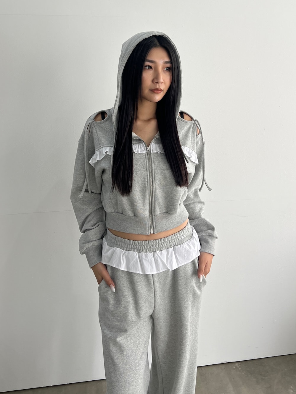 グレー系のパーカー、グレー系のスウェットパンツ、ブラック系のローファーを着用したレディースの冬コーディネートの3枚目の写真