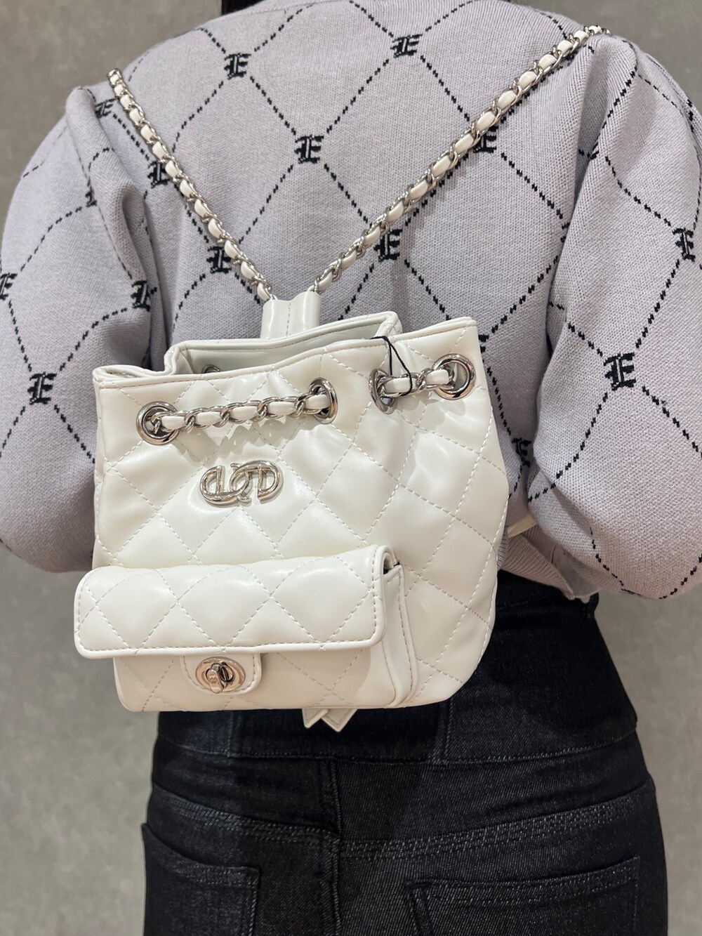 ブラック系のデニムパンツ、ブラック系のブーツ、グレー系のニット/セーターを着用したレディースの秋コーディネートの7枚目の写真