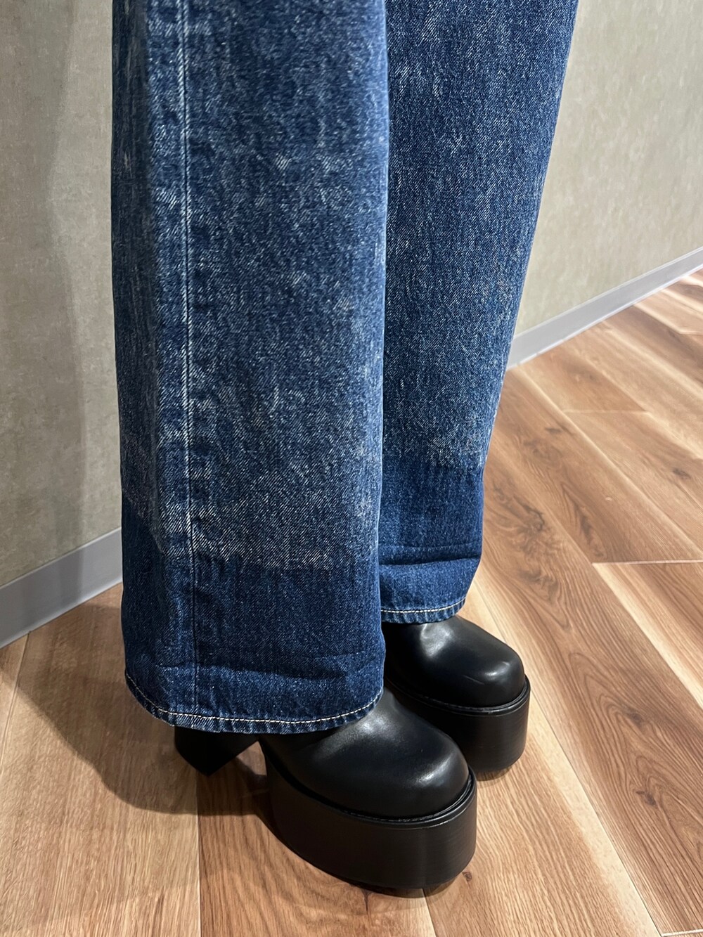 ブラック系のムートンコート、ホワイト系のシャツ/ブラウス、ブルー系のデニムパンツを着用したレディースの秋コーディネートの7枚目の写真