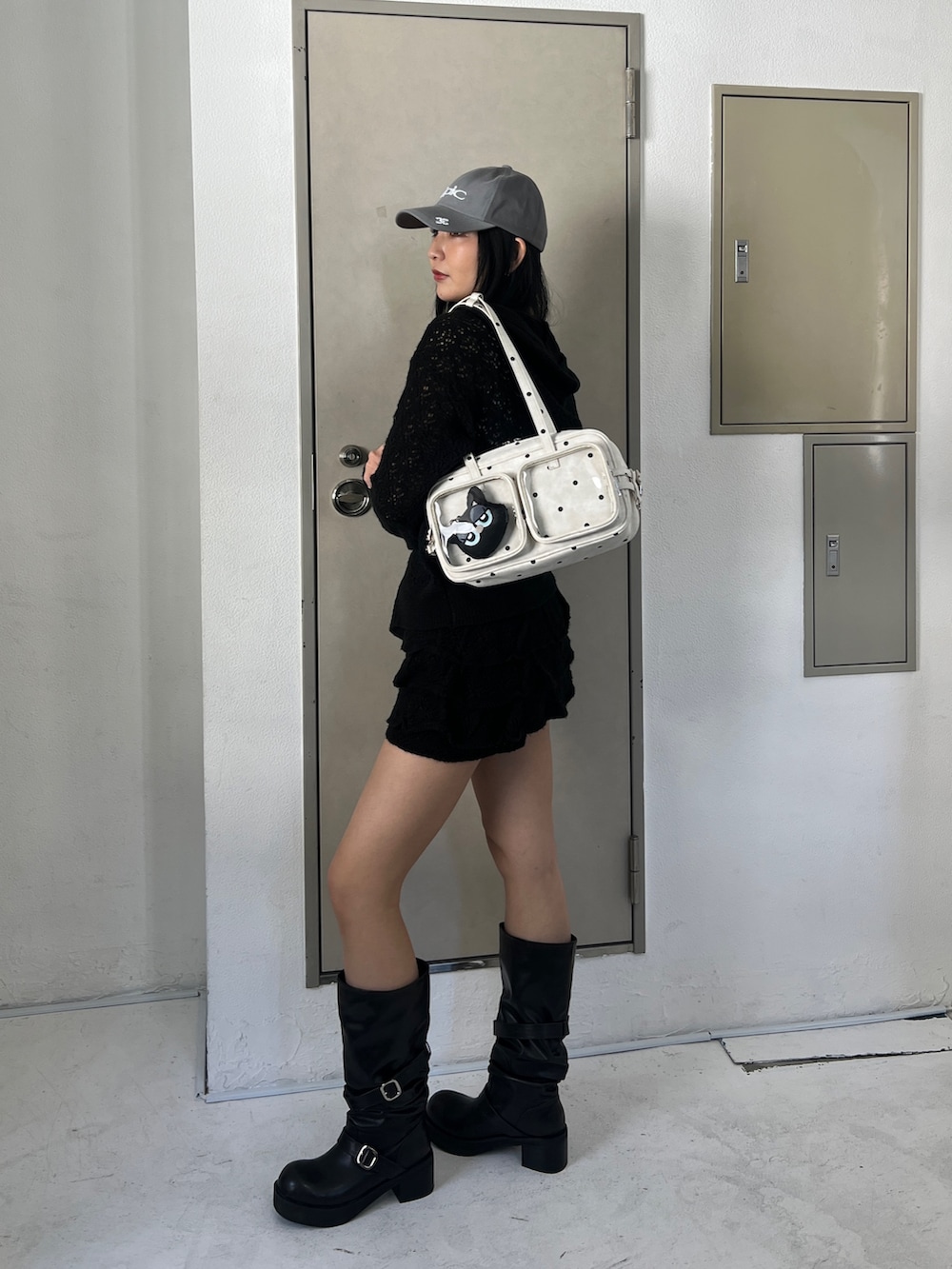 ブラック系のパーカー、ブラック系のスカート、ブラック系のブーツを着用したレディースの春コーディネートの2枚目の写真