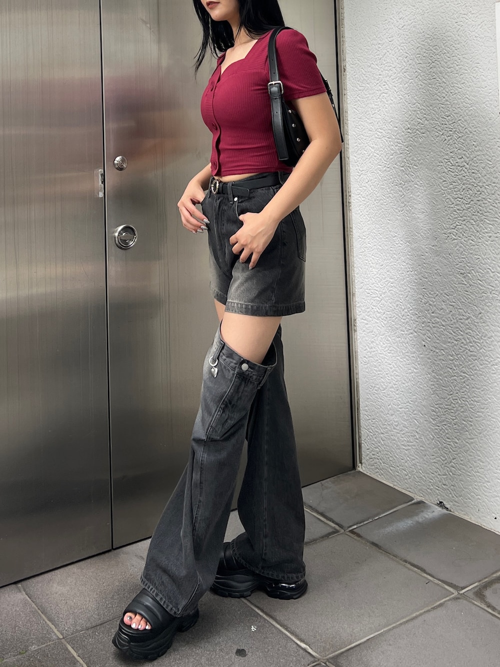 ブラック系のデニムパンツ、ブラック系のサンダル、ブラック系のハンドバッグを着用したレディースの夏コーディネートの2枚目の写真