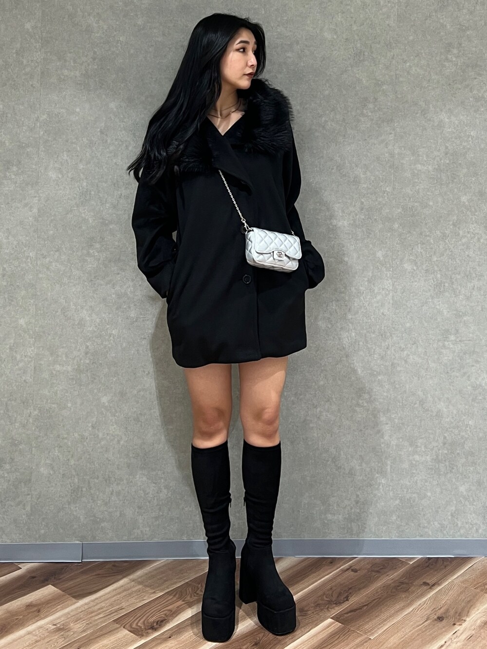 ブラック系のピーコート、その他のブーツ、ブラック系のスカートを着用したレディースの冬コーディネートの2枚目の写真