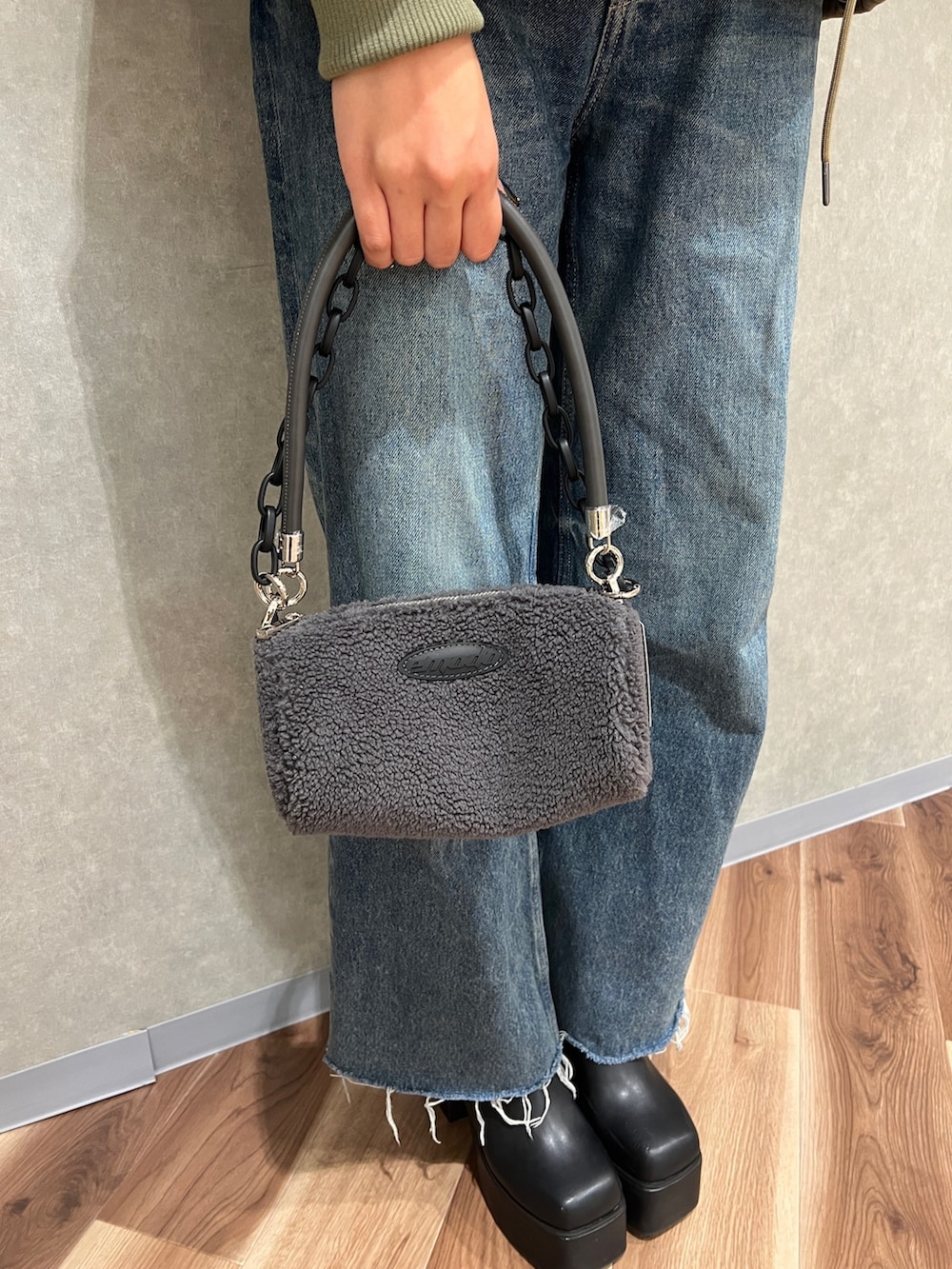 グリーン系のブルゾン、ブルー系のデニムパンツ、ブラック系のブーツを着用したレディースの秋コーディネートの6枚目の写真