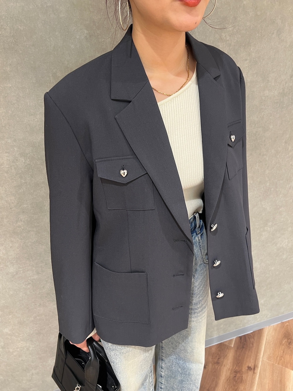 グレー系のテーラードジャケット、ブルー系のデニムパンツ、ブラック系のブーツを着用したレディースの冬コーディネートの5枚目の写真