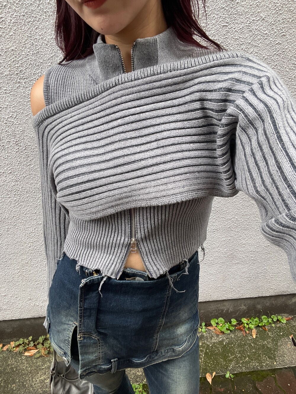 グレー系のニット/セーター、ブルー系のデニムパンツ、シルバー系のハンドバッグを着用したレディースの秋コーディネートの4枚目の写真