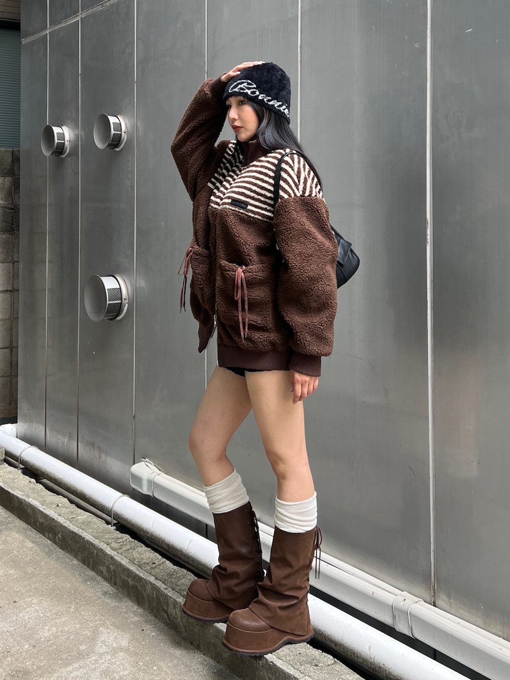 ブラウン系のブーツ、ブラック系のその他パンツ、ブラウン系のブルゾンを着用したレディースの秋コーディネートの2枚目の写真