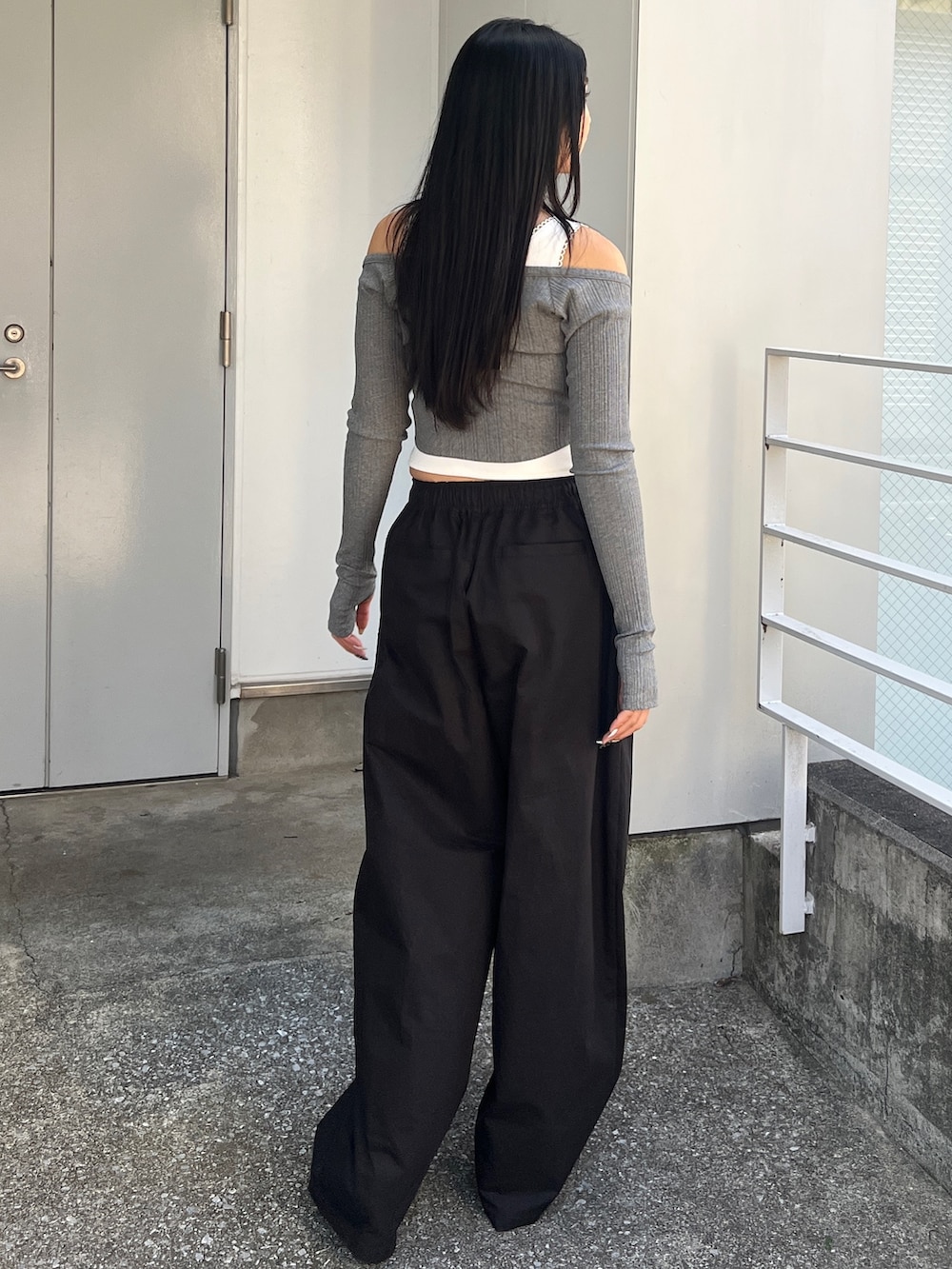 グレー系のTシャツ/カットソー、ブラック系のその他パンツ、ピンク系のスニーカーを着用したレディースの冬コーディネートの3枚目の写真