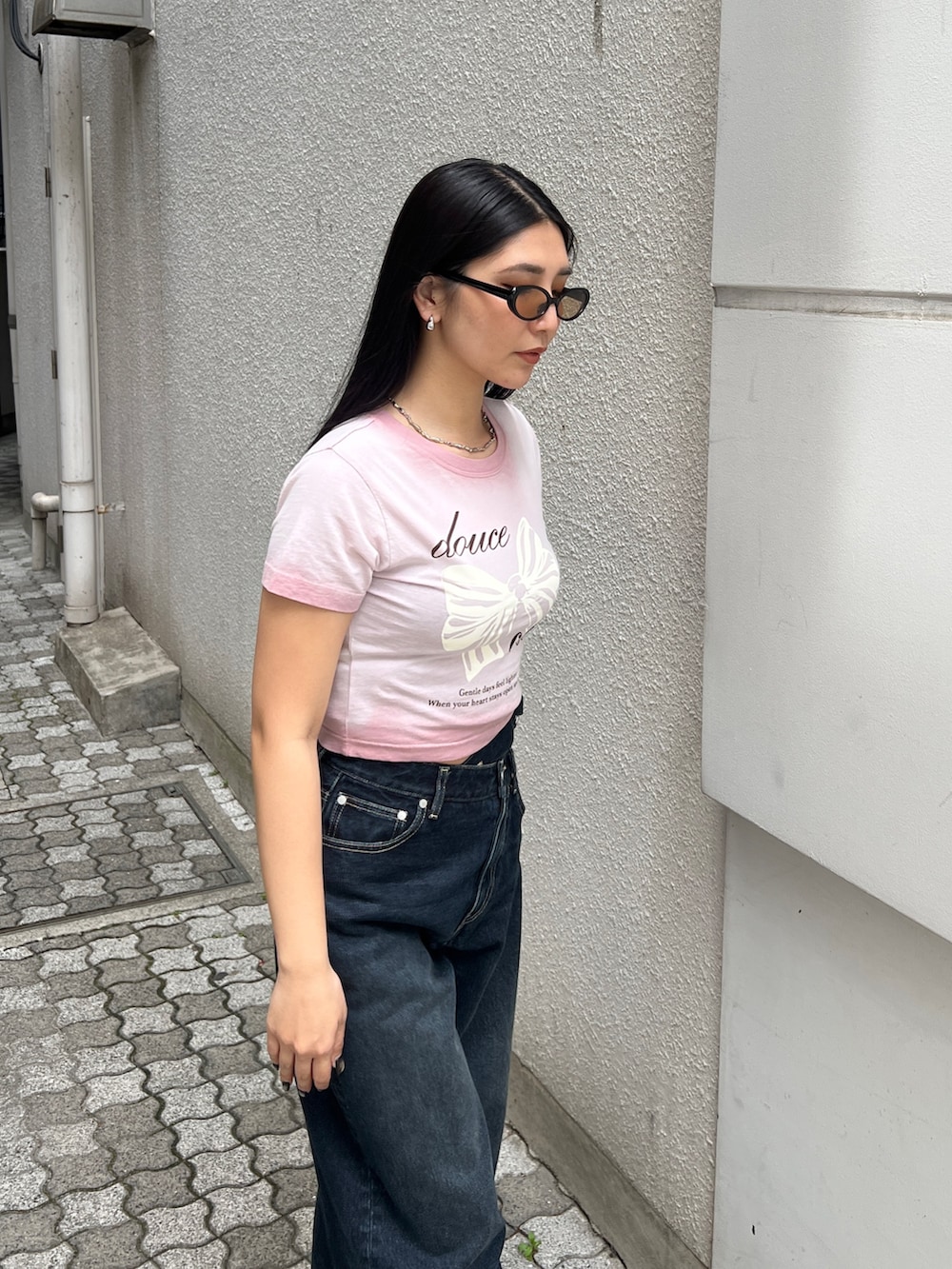 ピンク系のTシャツ/カットソー、ブルー系のデニムパンツ、ブラック系のサンダルを着用したレディースの夏コーディネートの4枚目の写真