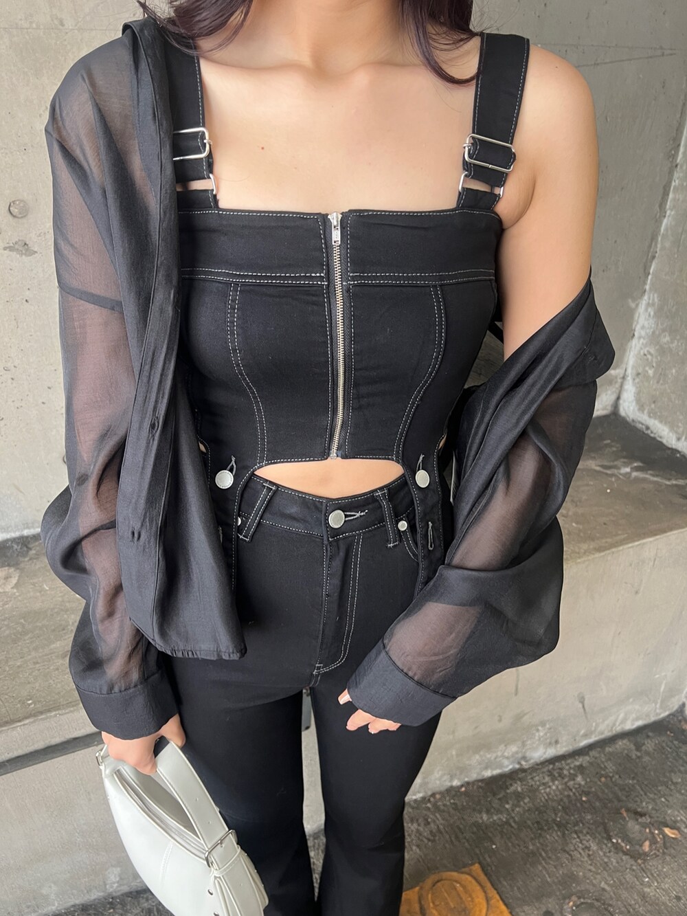 ブラック系のサロペット/オーバーオール、ブラック系のシャツ/ブラウス、ホワイト系のハンドバッグを着用したレディースの春コーディネートの4枚目の写真